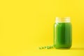 Bottle of green celery smoothie on yellow background. Banner with copy space. Fresh juice for detox. Vegan, alkaline healthy diet