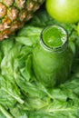 Bottle with Green Fresh Raw Smoothie from Leafy Greens Vegetables Fruits Apples Pineapple Bananas Kiwi Zucchini on Spinach Royalty Free Stock Photo