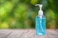 Bottle of Hand sanitizer blue gel alcohol on wooden table