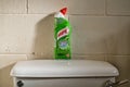 Bottle of Harpic toilet cleaner sat on top of a toilet cistern