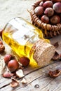 Bottle of healthy nut oil and basket with hazelnuts on table