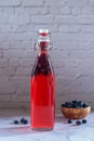 Bottles of homemade blueberry kombucha drink.