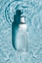 A bottle of hyaluronic acid lies in water.