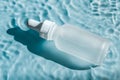 A bottle of hyaluronic acid lies in water.