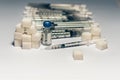 Bottle of insulin for diabetes and injection syringe, healthcare concept with refined loaf sugar cubes pile of syringes on