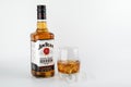 Bottle of Jim Beam Bourbon and a glass with ice on white background