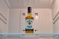 A bottle of Jim Beam whiskey bourbon alcohol on a shelf in an empty white refrigerator - Moscow, Russia, January 02, 2022