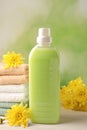 Bottle of laundry detergent, towels and beautiful flowers on white table Royalty Free Stock Photo