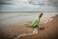 Bottle with letter on the beach sand Royalty Free Stock Photo