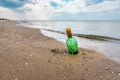 Bottle with letter stucked in the beach sand Royalty Free Stock Photo