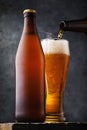 Bottle of light beer and a full glass of drink on a wooden table. Alcoholic still life Royalty Free Stock Photo