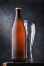 Bottle of light beer and two empty glasses on a wooden table Royalty Free Stock Photo