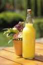 Bottle of limonade on wooden table with small bouquet