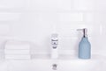 Bottle of liquid soap and stack of towels. Toiletries, towel and soap. Home background bathroom