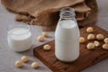 Bottle of macadamia milk on wooden board and macadamia milk in glass