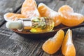 A bottle of mandarin essential oil and slices of ripe yellow mandarin lie on a wooden table Royalty Free Stock Photo