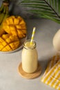 Bottle of mango, banana and yoghurt smoothie with a straw.