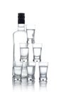 Bottle with many glasses of vodka isolated on white background