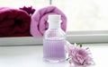 The bottle of massage oil put beside pink flower,aromatheraphy