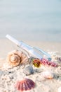 Bottle with a message or letter on the beach near seashell. SOS. Royalty Free Stock Photo