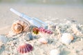 Bottle with a message or letter on the beach near seashell. SOS. Copy space. Royalty Free Stock Photo