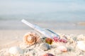 Bottle with a message or letter on the beach near seashell. SOS. Copy space. Royalty Free Stock Photo