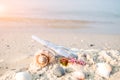 Bottle with a message or letter on the beach near seashell. SOS. Royalty Free Stock Photo