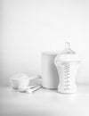 Bottle of milk for baby and measuring scoops with powder on light background