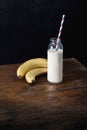 Healthy breakfast. Bottle milk with banana on wooden table Royalty Free Stock Photo