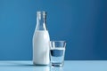 bottle of milk and a glass of water on a blue background Royalty Free Stock Photo