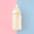 Bottle of milk for newborn baby over pink and blue pastel colors background. Maternity and baby care concept. Girl or boy. Top vie Royalty Free Stock Photo