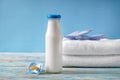 Bottle of milk with pacifier and towels on wooden table Royalty Free Stock Photo