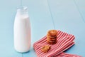Bottle of milk and pile of chocolate chip cookies on napkin on blue wooden table Royalty Free Stock Photo