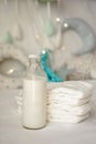 Bottle of milk with stack of diapers on bed Royalty Free Stock Photo