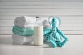 Bottle of milk, stack of towels and toy on white table