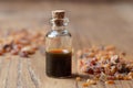 A bottle of myrrh essential oil with myrrh resin on a table Royalty Free Stock Photo