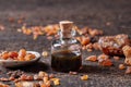 A bottle of myrrh essential oil with myrrh resin on a table