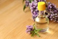 Bottle of natural essential oil and lavender flowers on wooden table, closeup. Space for text Royalty Free Stock Photo