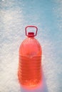 Bottle with non-freezing windshield washer fluid, snow background