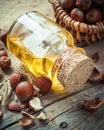 Bottle of nut oil and basket with filberts on table