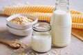 Bottle of oat milk and oat grains in bowl on table Royalty Free Stock Photo