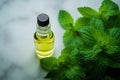 Bottle of oil with green leaves. Essential oil of peppermint in bottle with fresh green.