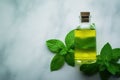 Bottle of oil with green leaves. Essential oil of peppermint in bottle with fresh green.