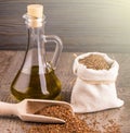 Bottle of oil sesame seeds in sack on wooden table on soft sunlight Royalty Free Stock Photo