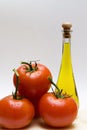 Bottle of oil and three tomatoes Royalty Free Stock Photo