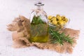 A bottle of olive oil with a branch of rosemary in the inside on a white background. Close-up. Royalty Free Stock Photo