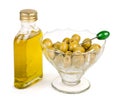 Bottle of olive oil with green olives watered with oil