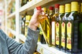 Bottle of olive oil in hand buyer at grocery Royalty Free Stock Photo