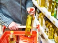 Bottle of olive oil in hand buyer at grocery Royalty Free Stock Photo