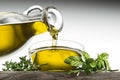 Bottle of Olive oil with herbs pouring in glass bowl Royalty Free Stock Photo